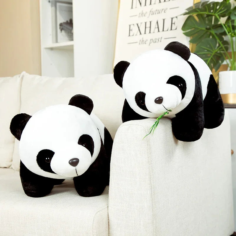 Deux peluches panda avec ses feuilles de bambou sur canape