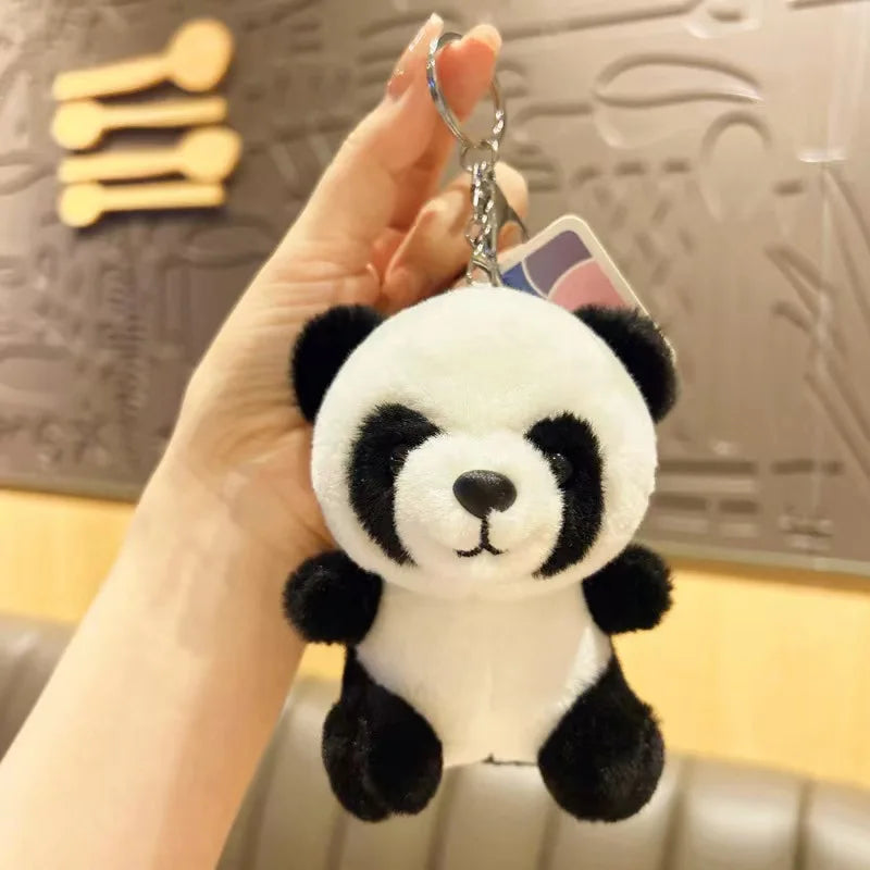 Mini peluche panda tenue par la main d'une fille