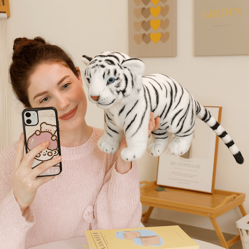 Peluche bébé tigre blanc douce tenu par une main par une fille