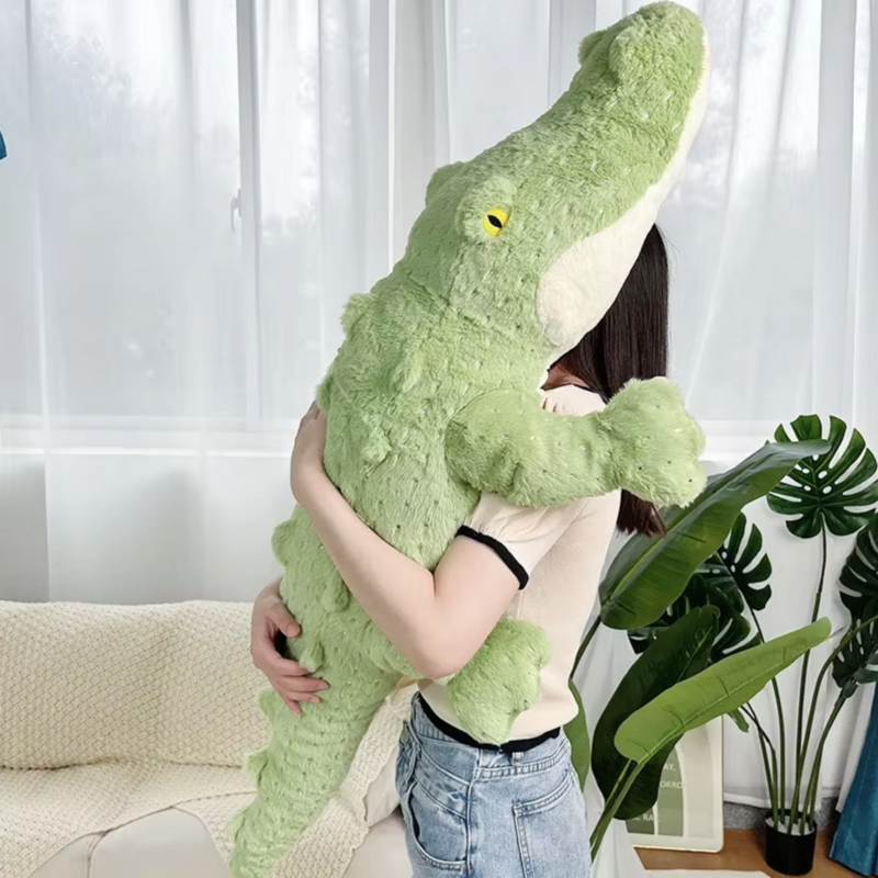 Peluche crocodile doux tenu par une fille dans les bras