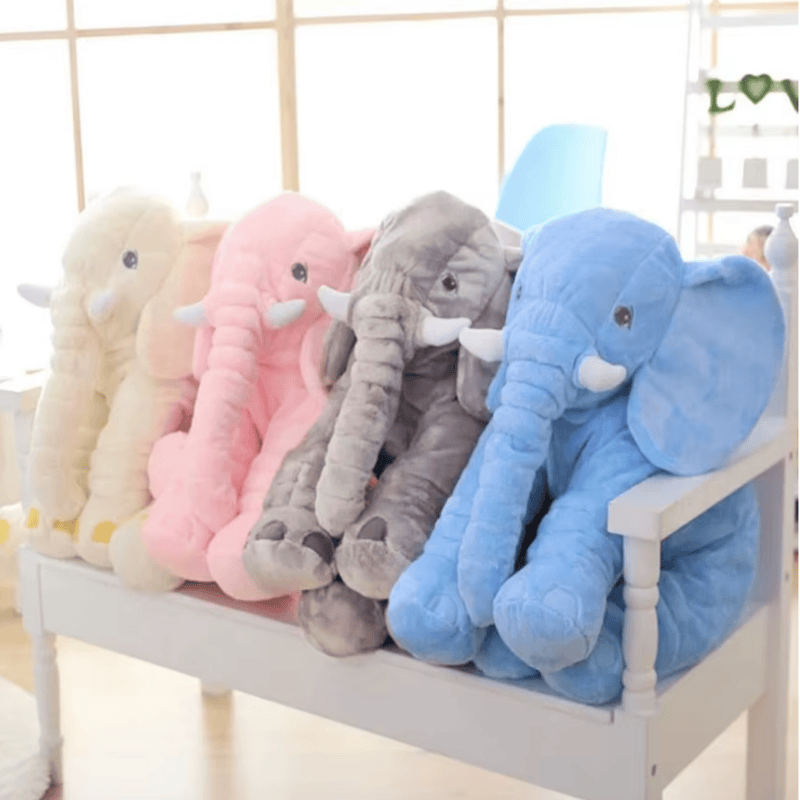 Peluches éléphants jaune, rose, gris, bleu sur un banc d'enfant