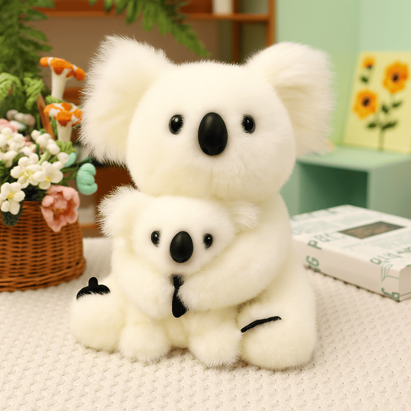 Peluche koala blanc mère et fils sur une nappe sur une table