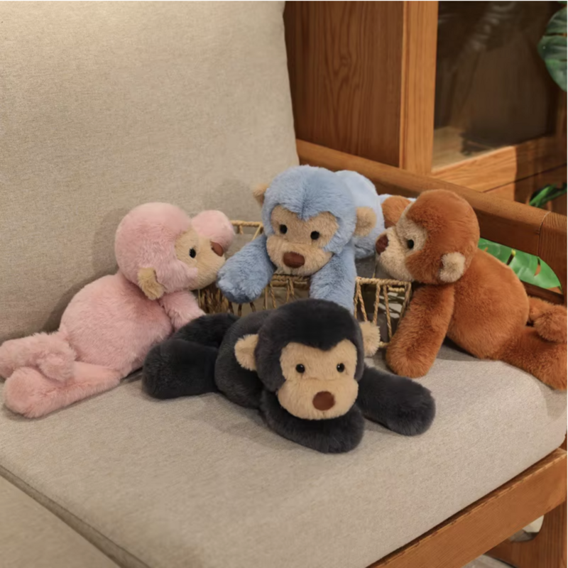 Quatre peluches singes douces couchés sur panier en osier étant posés sur un fauteuil