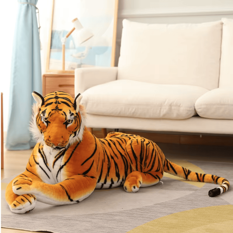 Peluche tigre orange allongé sur un tapis