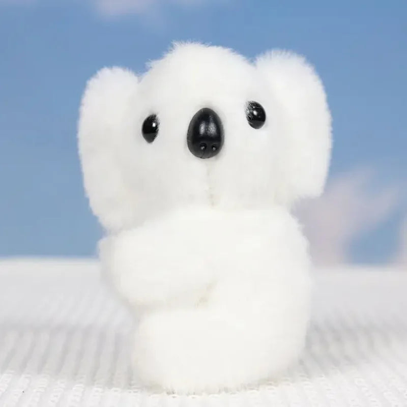 Mini peluche koala blanc sur un drap