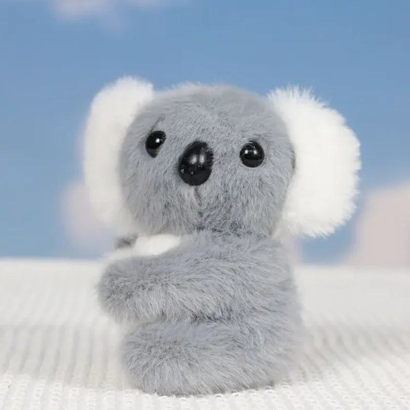 Mini peluche koala gris sur un drap