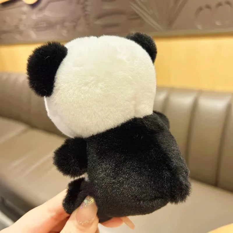 Mini peluche panda de dos tenue par la main d'une fille