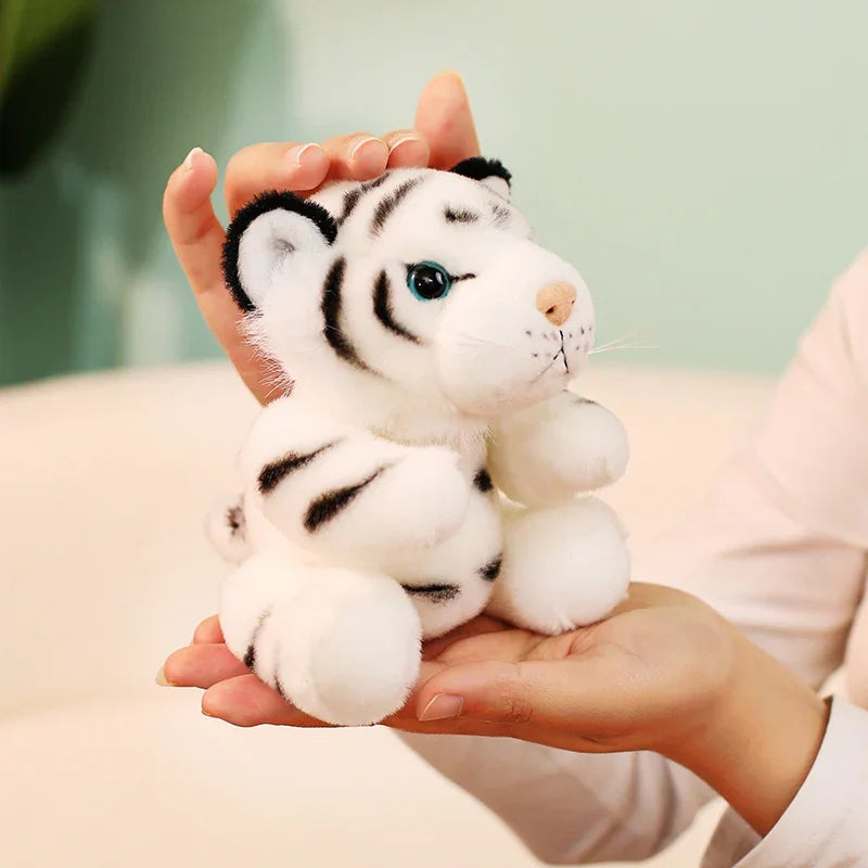 Mini peluche tigre blanc dans les mains d'une fille