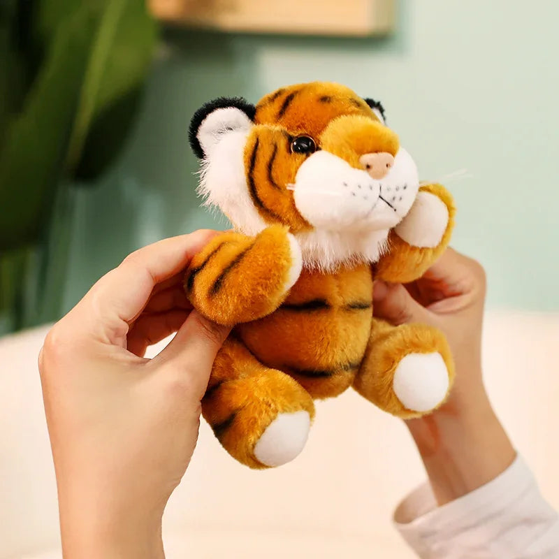 Mini peluche tigre orange dans les mains d'une fille
