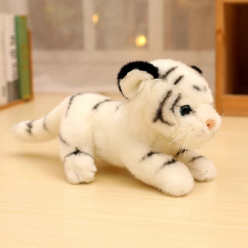 Peluche bébé tigre blanc couché sur une table