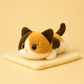 Peluche chat mignon calico sur une couverture