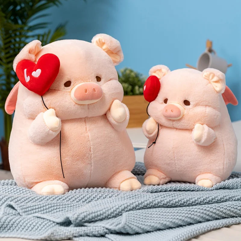 Deux peluches cochons amoureux sur une couverture sur un lit 