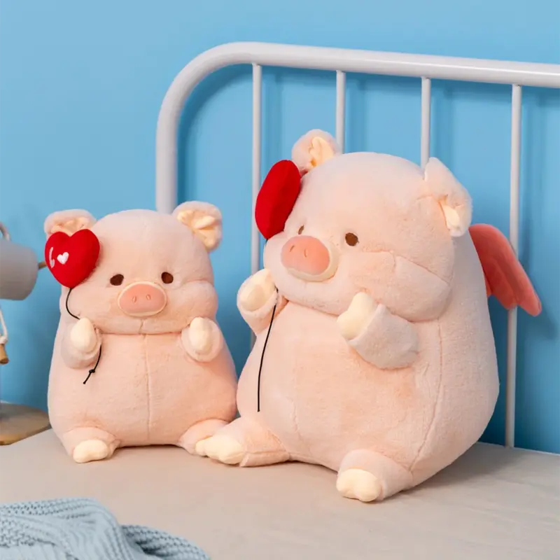 Deux peluches cochons amoureux sur un lit 