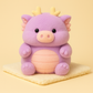 Peluche cochon dragon violet sur une couverture