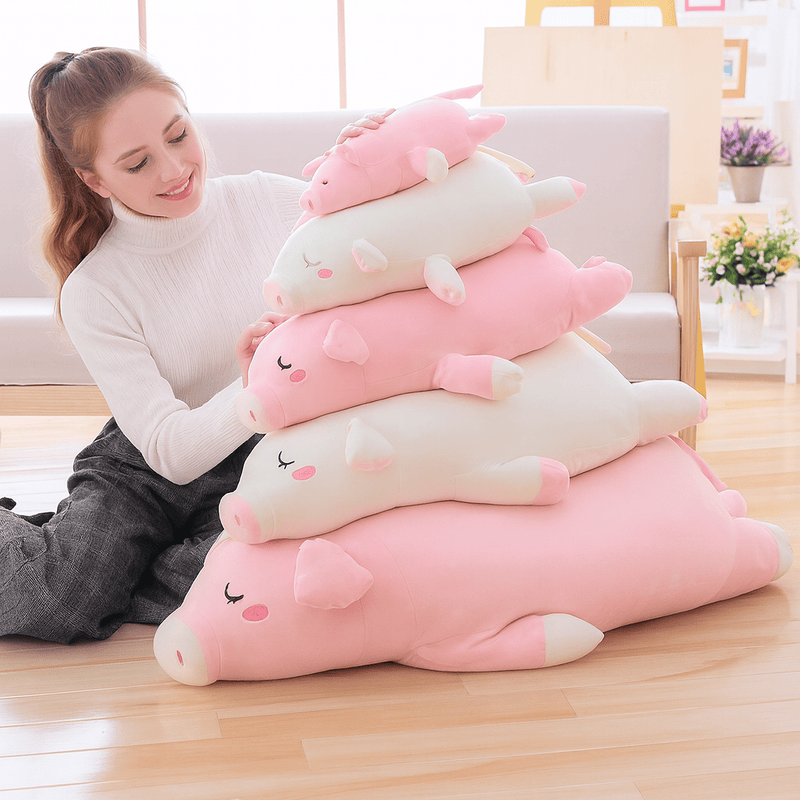 Cinq peluches cochons endormi entassé sur eux-mêmes tenu par une fille