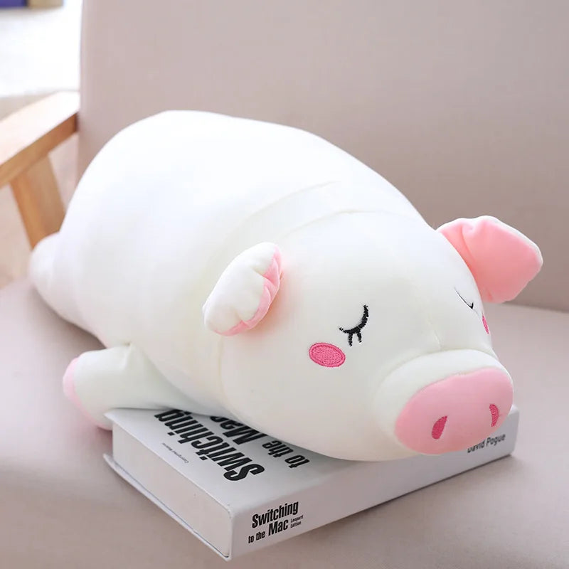 Peluche cochon blanc endormi sur un livre