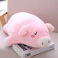 Peluche cochon rose endormi sur un livre