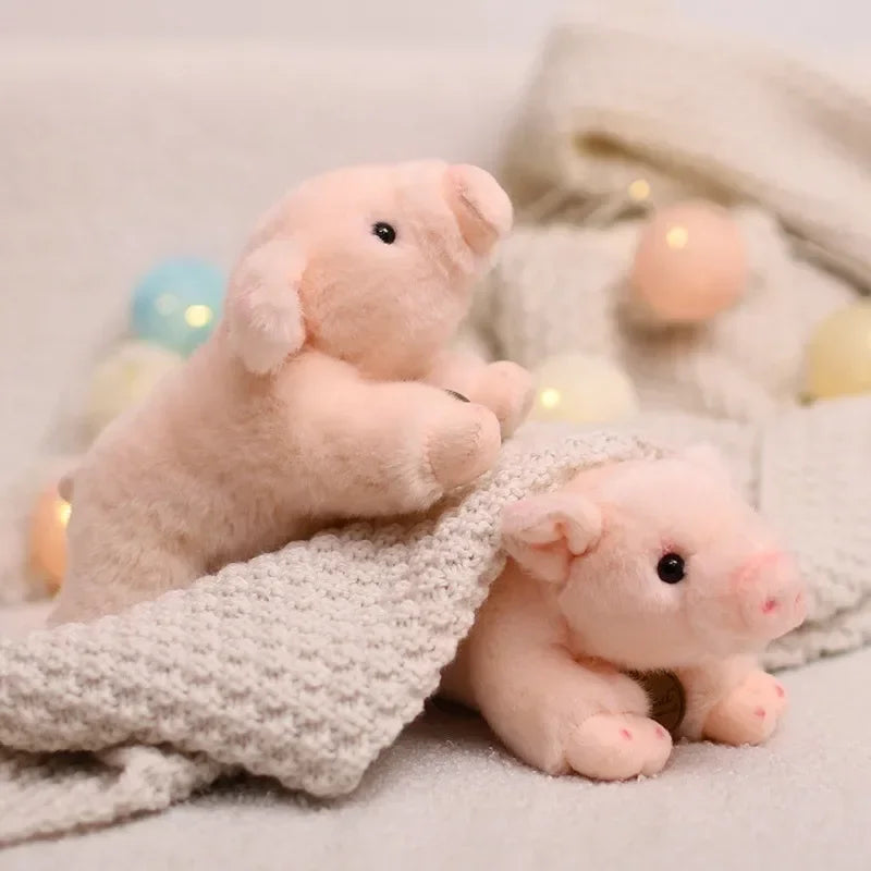Deux peluches cochons mignons sur une couverture et l'autre en dessous 