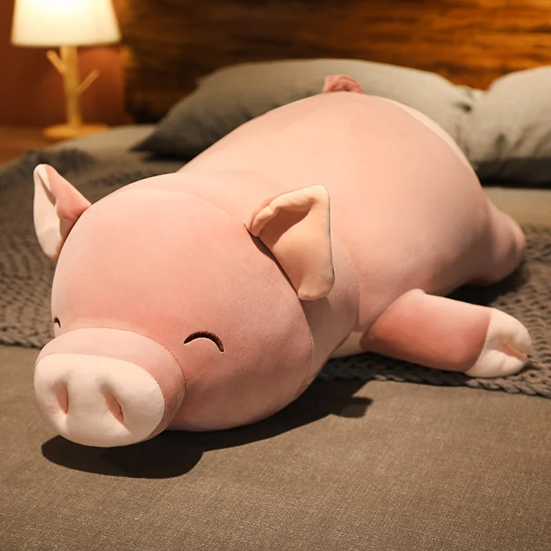 Peluche cochon smile couché sur un lit