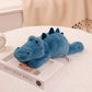 Peluche crocodile bleu couché sur un livre 