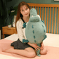 Peluche crocodile cartoon tenu par une fille sur un lit