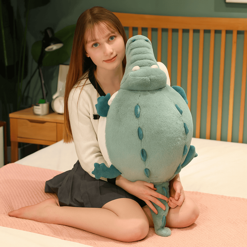 Peluche crocodile cartoon tenu par une fille sur un lit