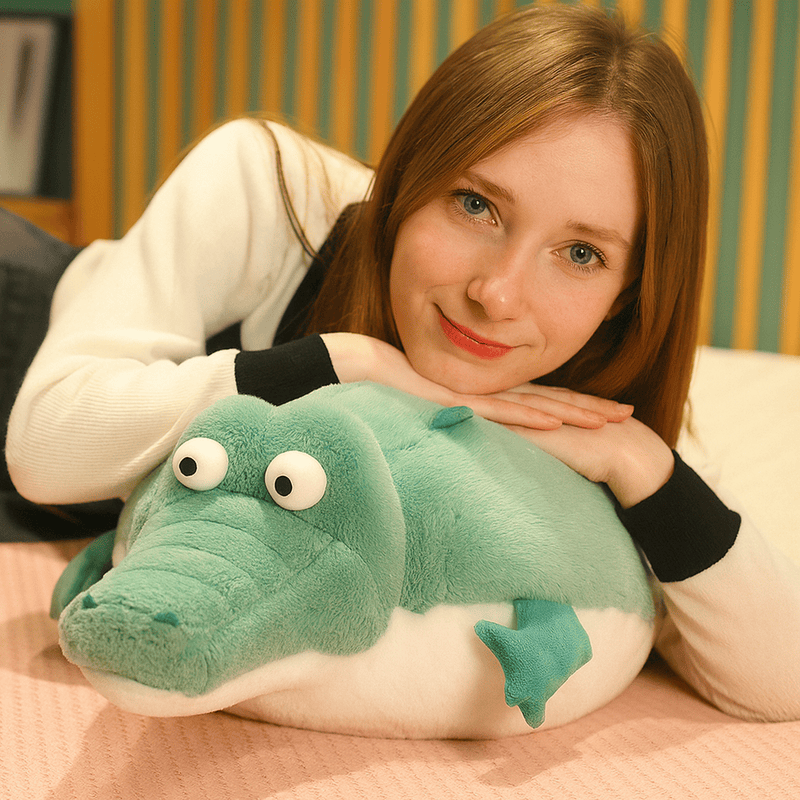 Peluche crocodile cartoon écrasé par une fille ayant les mains et la tête dessus