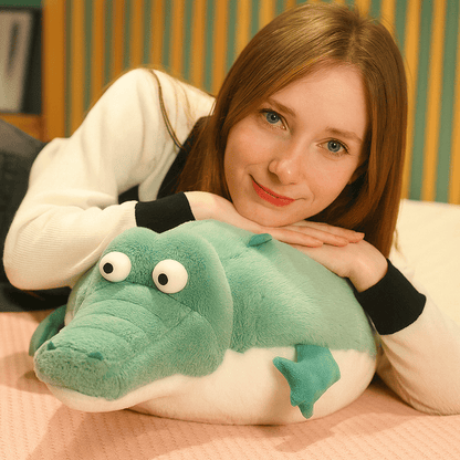 Peluche crocodile cartoon écrasé par une fille ayant les mains et la tête dessus