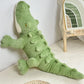 Peluche crocodile doux contre un mur