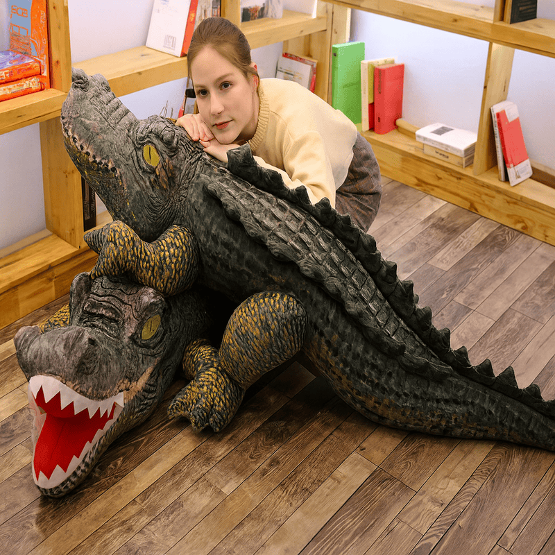 Deux peluches crocodiles préhistoriques sur un parquet avec une fille posant pour la photo