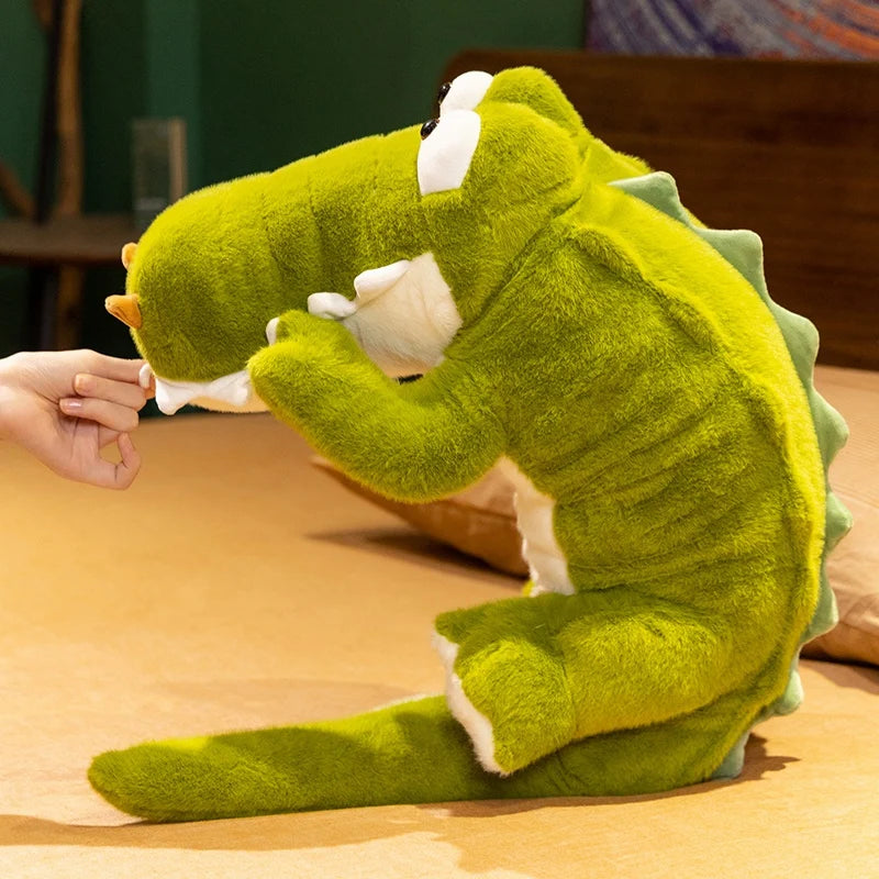 Peluche crocodile rigolo aux gros yeux enroulé debout sur le lit