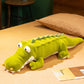 Peluche crocodile rigolo aux gros yeux couché sur le lit