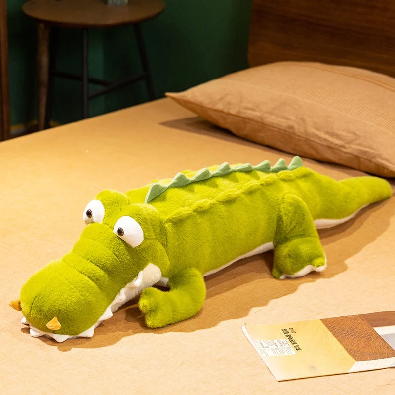 Peluche crocodile rigolo aux gros yeux couché sur le lit