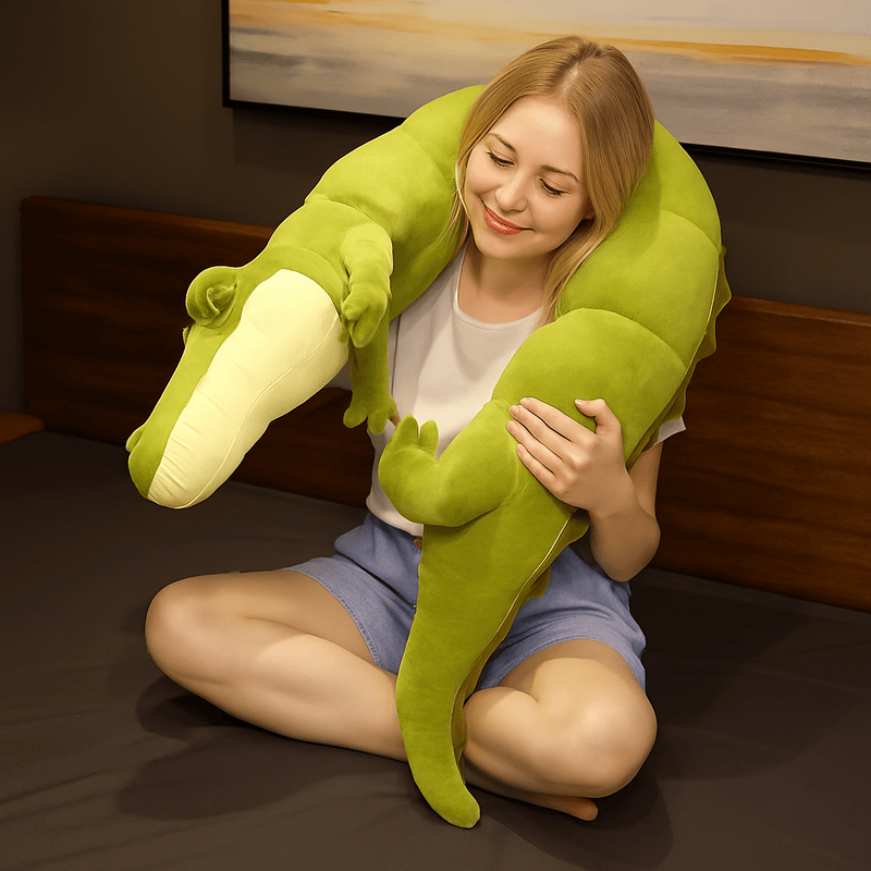 Peluche crocodile xxl autour du cou d'une femme assise sur un lit