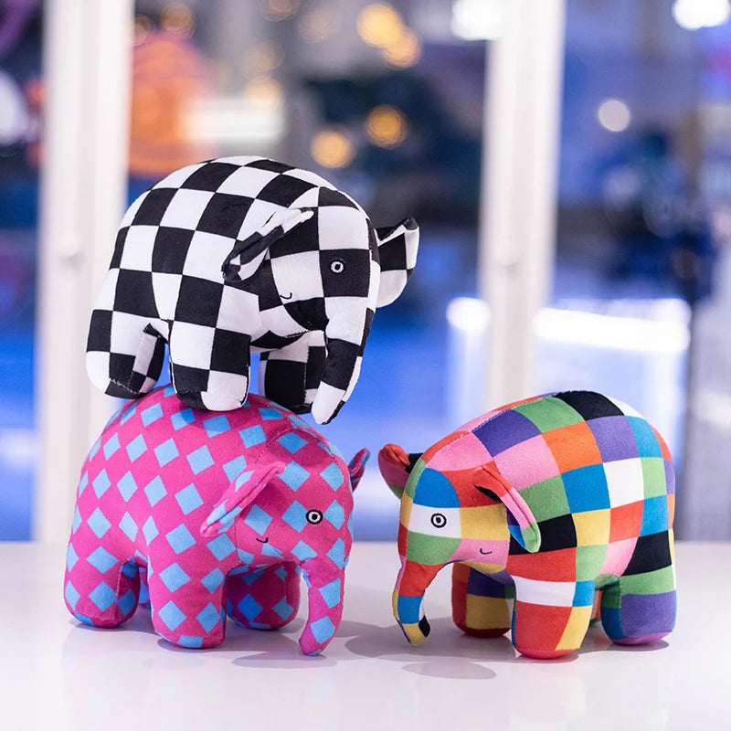 Trois peluches éléphant à carreaux sur une table