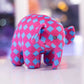 Peluche éléphant à carreaux rose à carreaux bleu sur une table