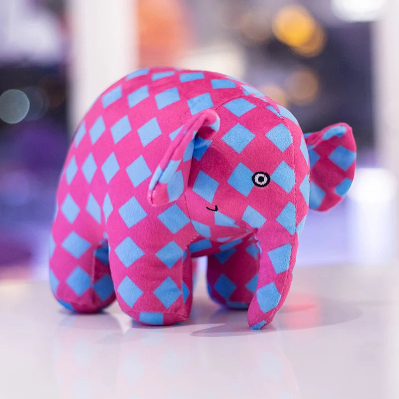 Peluche éléphant à carreaux rose à carreaux bleu sur une table