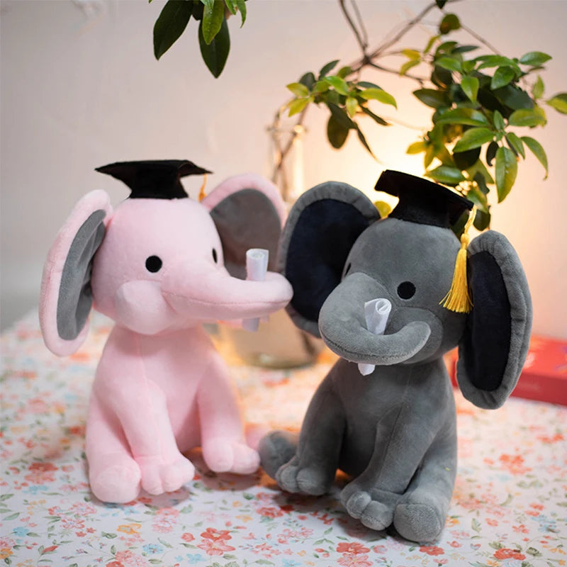 Deux peluches éléphants rose et grise diplômé sur une table