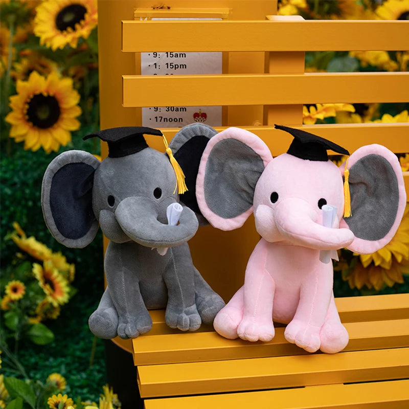 Deux peluches éléphants rose et grise diplômé sur un banc jaune