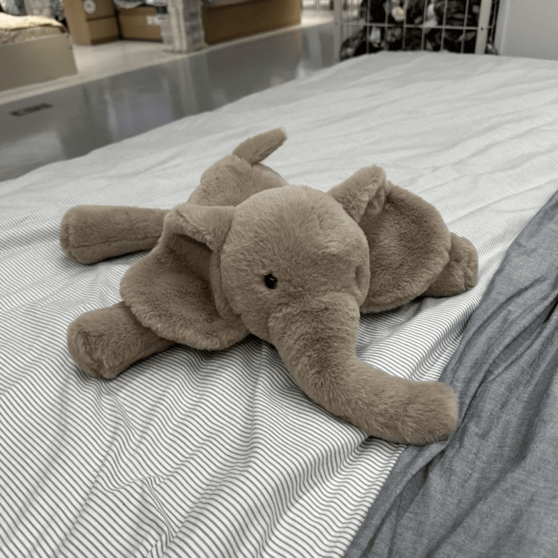 Peluche éléphant grise super douce sur un lit