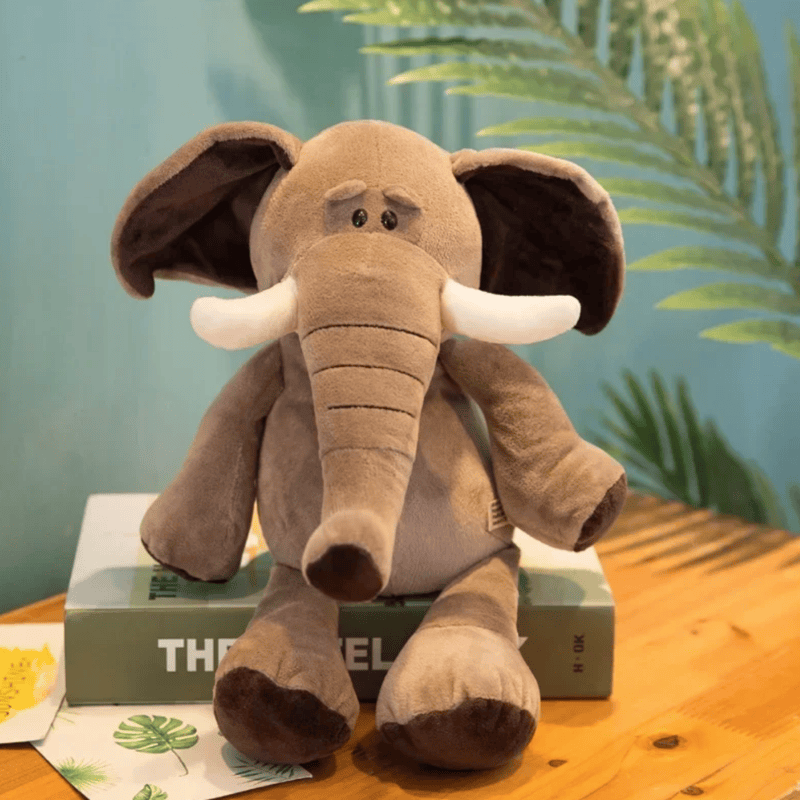 Peluche éléphant kawaii sur un livre sur un bureau 
