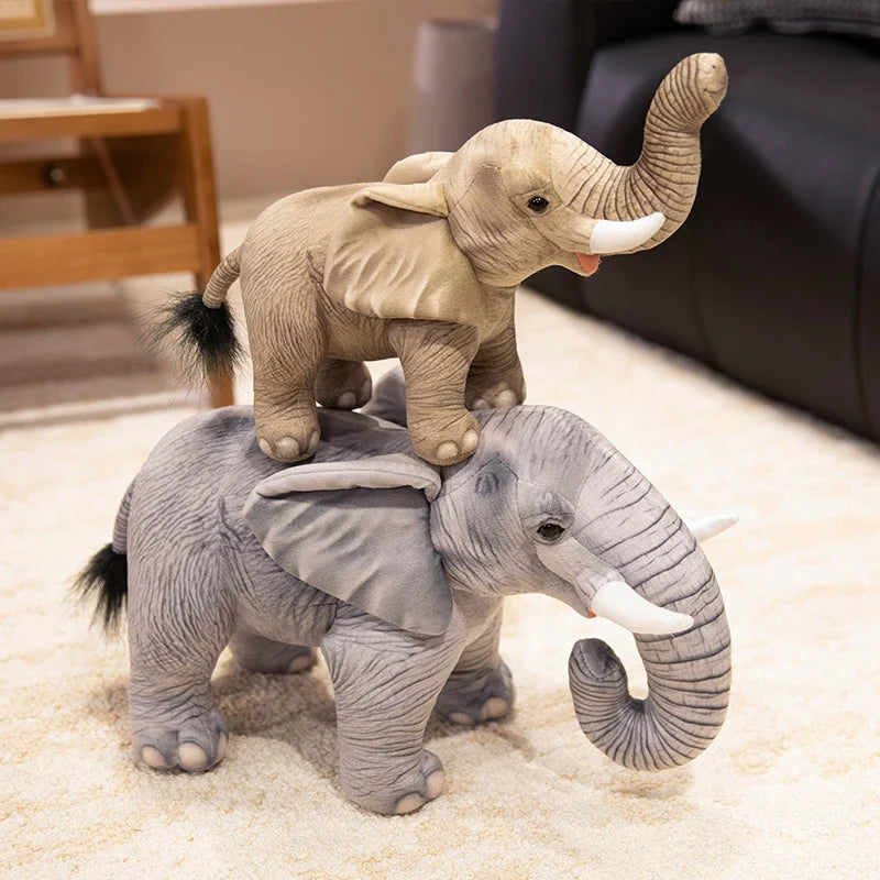 Une petite peluche éléphant marron réaliste sur le dos d'une grande peluche éléphant grise réaliste sur un tapis 