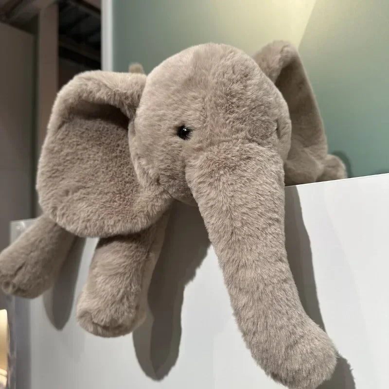 Peluche éléphant grise super douce sur un rebord de porte