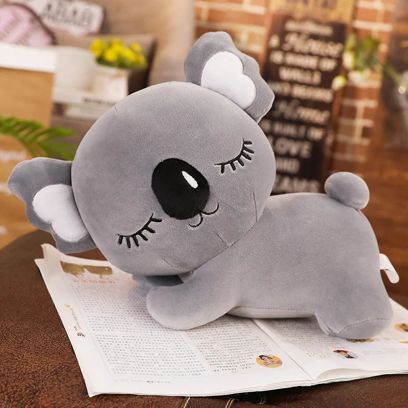 Peluche koala gris endormi sur un livre