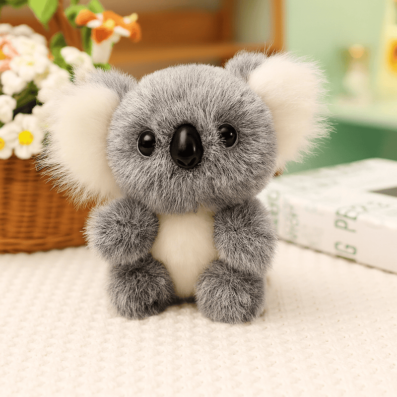 Peluche koala gris grande famille sur une nappe sur une table