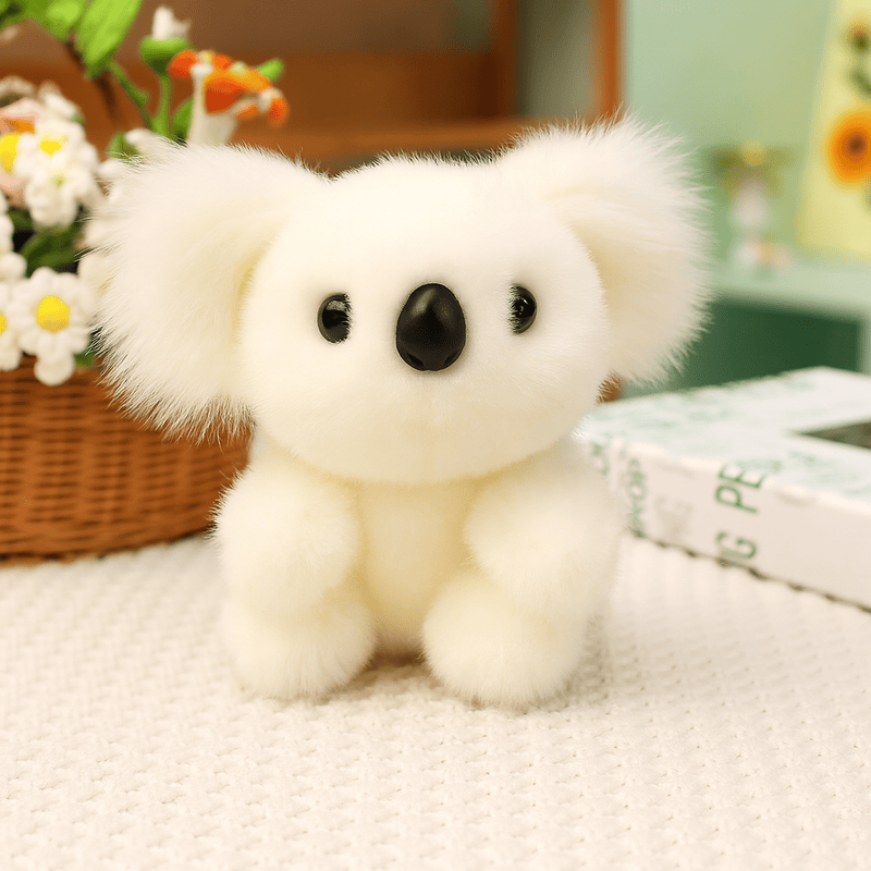 Peluche koala blanc grande famille sur une nappe sur une table