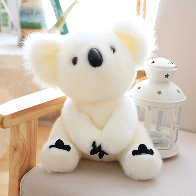 Peluche koala blanc grande famille sur un banc avec un coussin avec une lampe à bougie