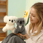 Deux peluches koala gris grande famille dans la main d'une femme