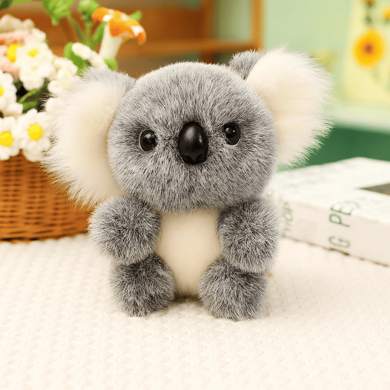 Peluche koala gris grande famille sur une nappe sur une table