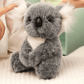 Peluche koala gris grande famille sur une nappe sur une table